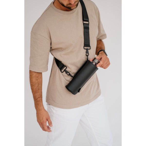 Dank dem Tragegurt der an der schwarzen faux-leather Schutzhülle befestigt ist kann die Crossbody Glastrinkflasche wie eine Tasche getragen werden. So bleiben die Hände frei. Praktisch für unterwegs.