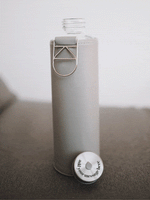 Glastrinkflasche kann ergänzt werden mit zahlreichen passenden Schutzhüllen aus faux-leather oder Filz. Schützt die Glasflasche auch für den Gebrauch unterwegs. Diese kommt mit einer grauen Hülle. Deckel kann graviert werden mit Ihrer Message wie auf dem Bild.