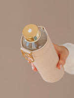 Stylishe Trinkflasche aus Glas mit beiger Hülle.