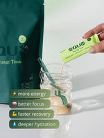 Frisch zubereitetes EQUA Recharge Tonic Zitrone-Grüntee Elektrolyt-Getränk im Glas mit Eiswürfeln und Zitrone