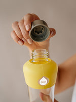 Stilvolle und zeitlose Glas Trinkflasche mit Silikonschutz unten und oben (Farbe mint oder zartes pastell gelb) für unterwegs. Trinkflasche Glas transparent ohne Design oder Druck ausser EQUA Logo in weiss.