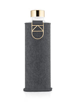 EQUA Trinkflasche Blueberry Pie 750 ml - transparente Glasflasche mit Filz Schutzhülle in der Farbe graphite und goldenem Deckel.