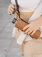 Sportliche Glastrinfklasche in faux-leather Schutzhülle marple mit schwarzem Tragegurt - crossbody getragen. So hat man die Hände frei auch wenn man keine Tasche dabei hat.