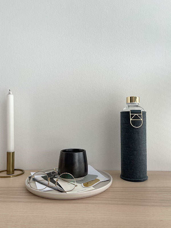 Glastrinkflasche kann ergänzt werden mit zahlreichen passenden Schutzhüllen aus faux-leather oder Filz. Schützt die Glasflasche auch für den Gebrauch unterwegs. Diese kommt mit einer schwarzen Graphite farbenen Hülle aus Filz. 