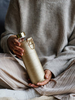 Glastrinkflasche kann ergänzt werden mit zahlreichen passenden Schutzhüllen aus faux-leather oder Filz. Schützt die Glasflasche auch für den Gebrauch unterwegs. Diese Glaswasserflasche kommt in einer hell goldnene Hülle - chic und gut kombinierbar.