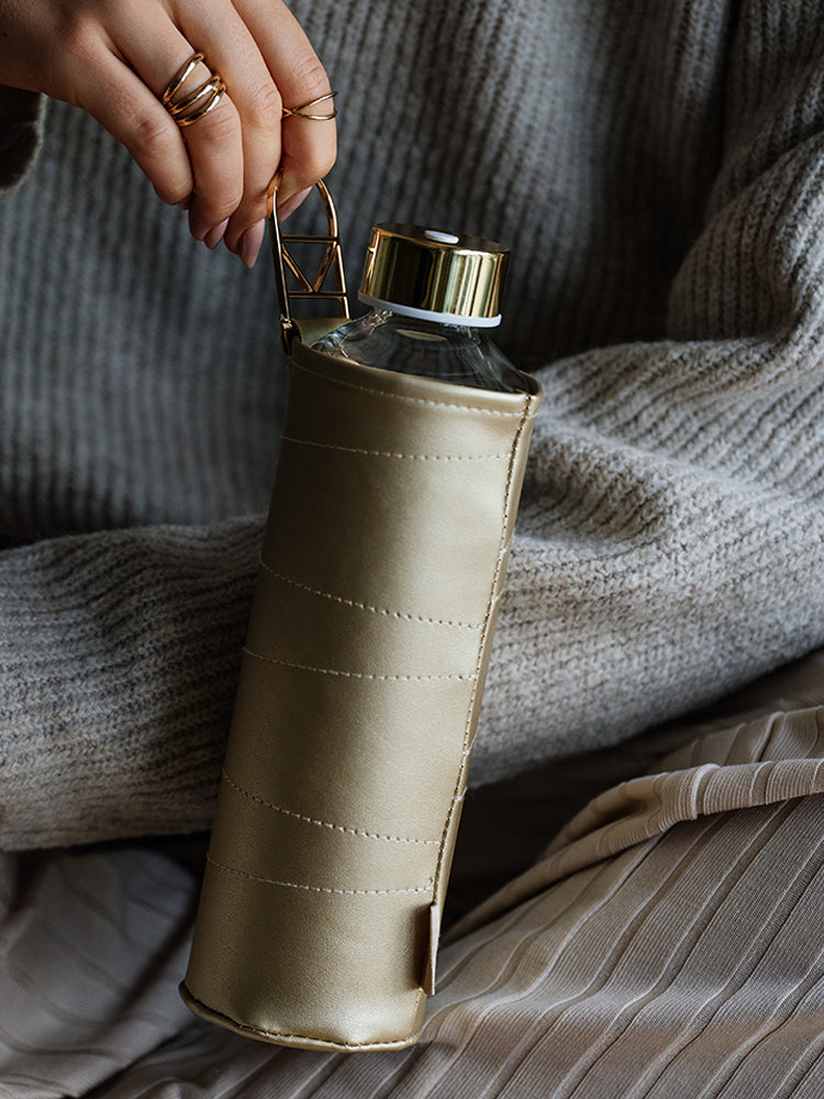 Glastrinkflasche in goldener Hülle - cool auch für Frauen die es minimalistisch mögen und trotzdem etwas glamour. Passt wie auf dem Bild wunderschön zu grau.