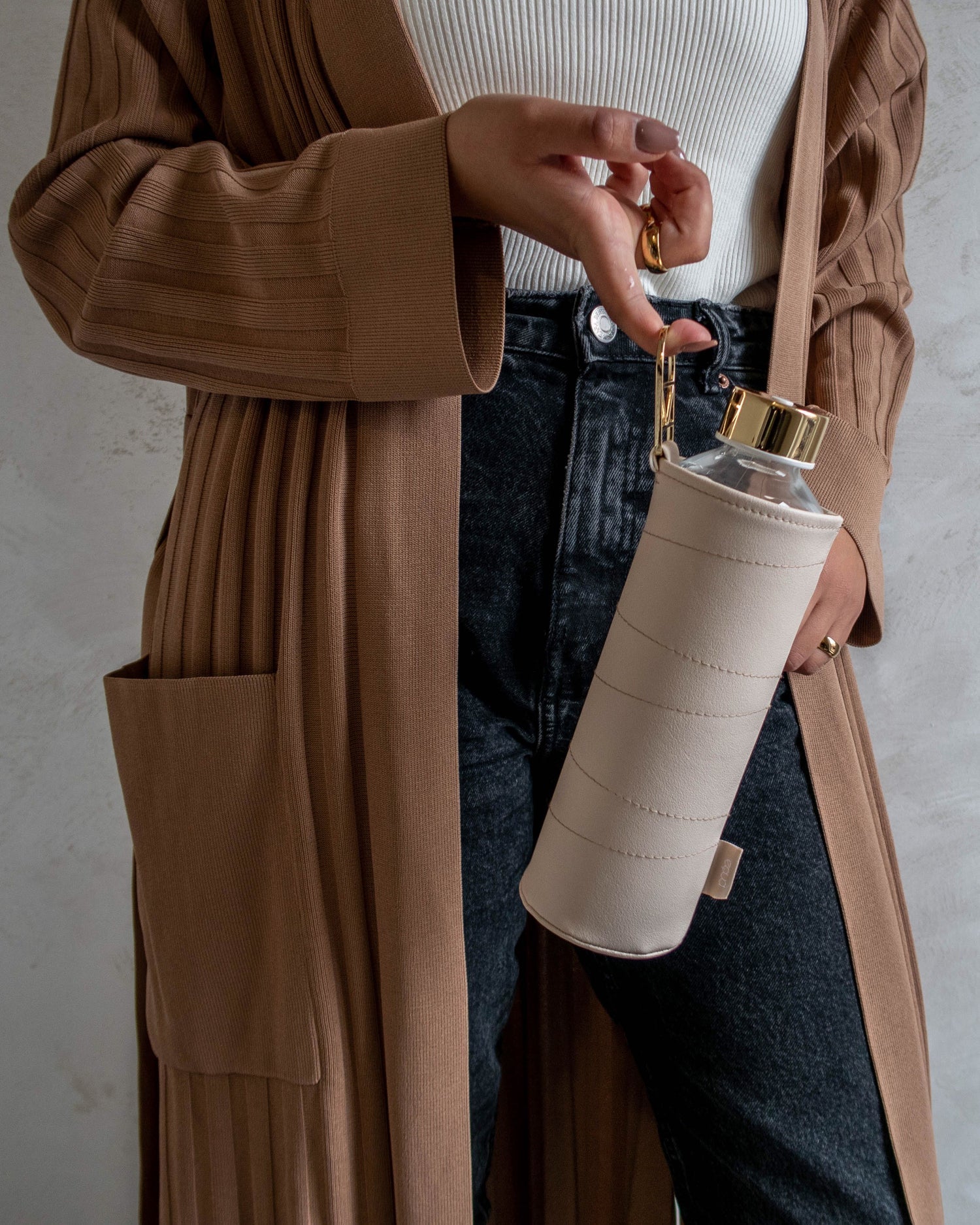 Glastrinkflasche kann ergänzt werden mit zahlreichen passenden Schutzhüllen aus faux-leather oder Filz. Schützt die Glasflasche auch für den Gebrauch unterwegs. Diese kommt mit einer beigen Hülle.